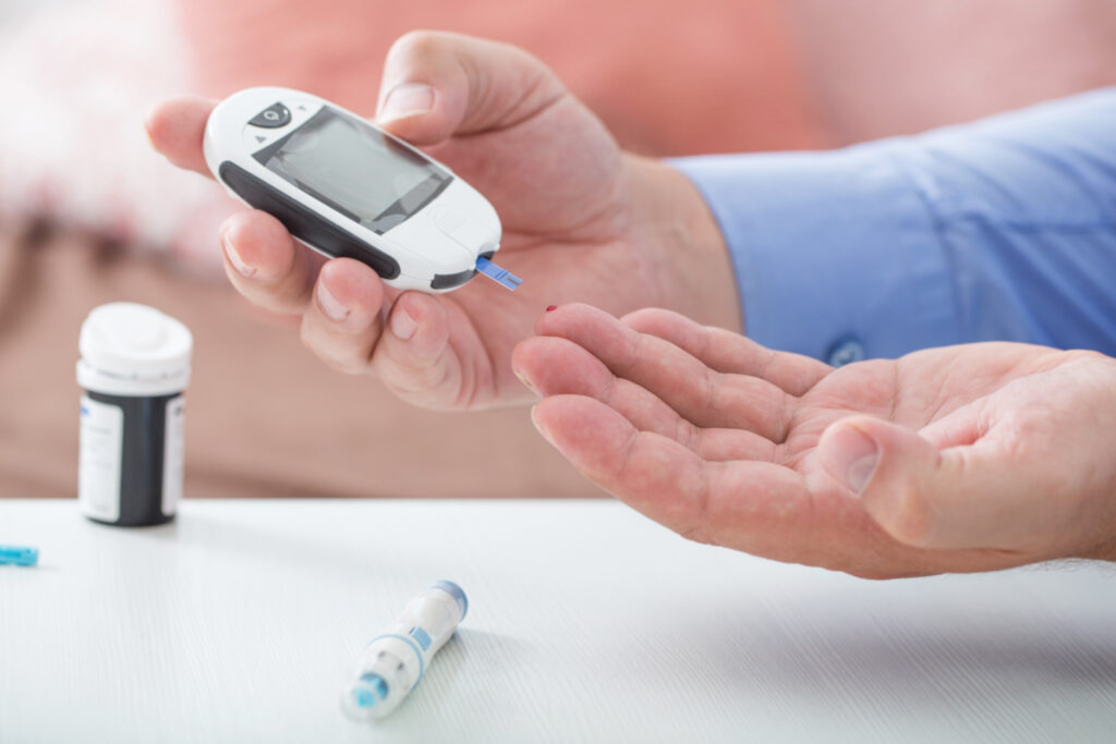 Man pricking finger to test his blood sugar so is diabetic neuropathy gets better